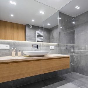 Modern bathroom with wooden countertop, shower, basin and big mirror